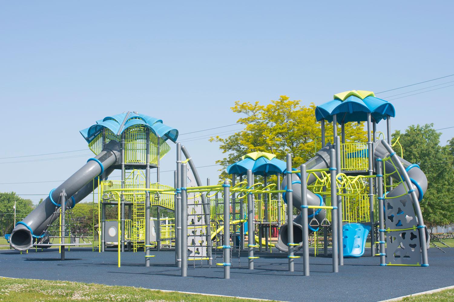 A tall playground structure with grey tube slides.