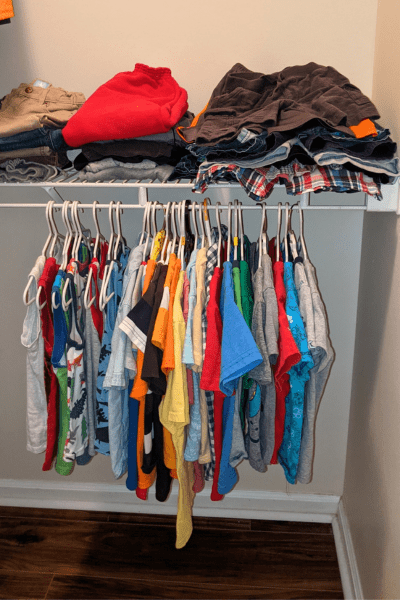 A kid's closet with clothes on hangers