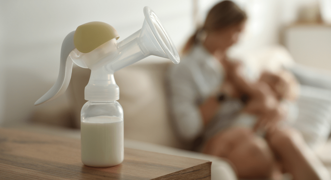A manual breast pump sits on a table.