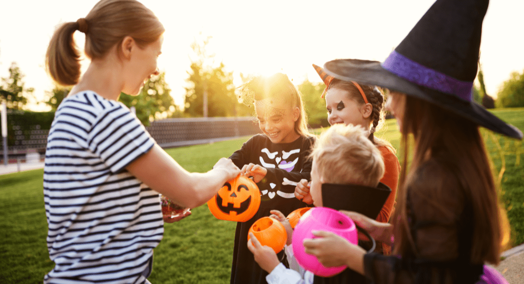 Kids in costume get candy trick or treating.