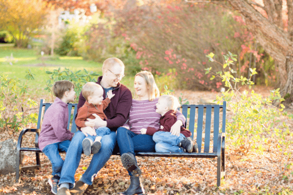 A photo by Jackie Rutan Photography of a family on a park bench.