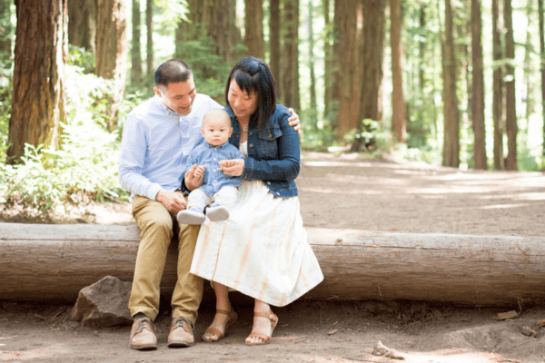 A family sits on a fallen tree in a photo by Jackie Rutan Photography.