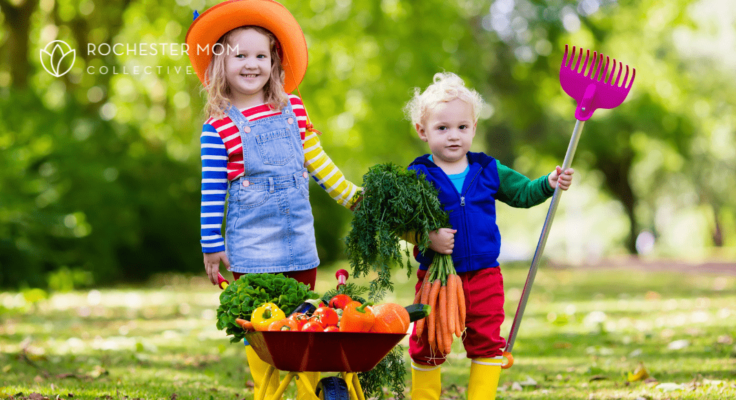 Kids with a wheelbarrow of colorful vegetables