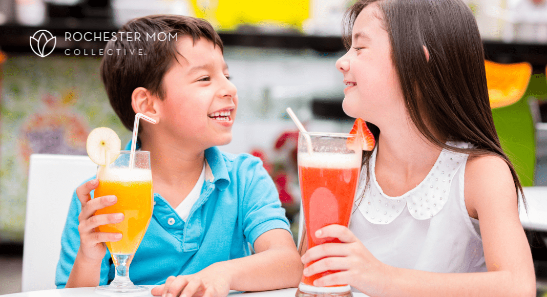 Kids sit at a table with fun colorful drinks.
