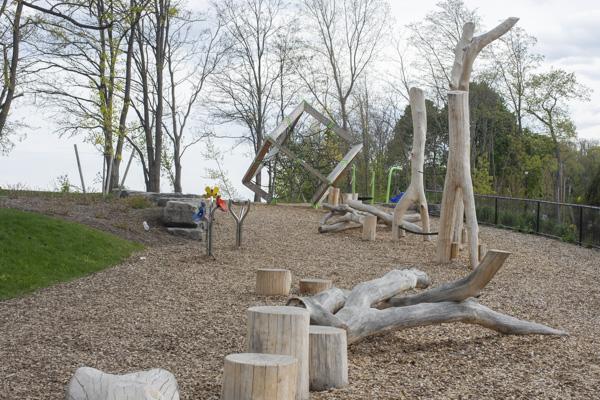 A natural playground with tree trunks and a cube climbing apparatus.