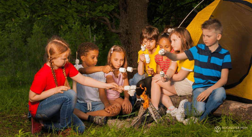 Kids roast marshmallows at a campfire.