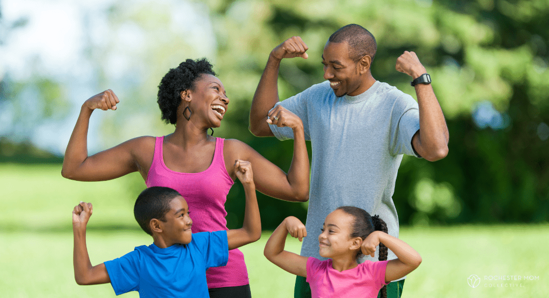 A family poses together showing their strong muscles.