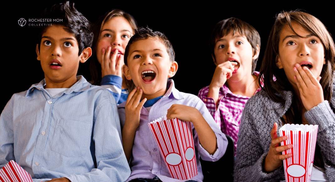 kids enjoy eating popcorn outside at a nighttime event.